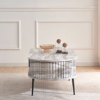 Grey marble effect oval coffee table with fluted base, in a modern home, side view.