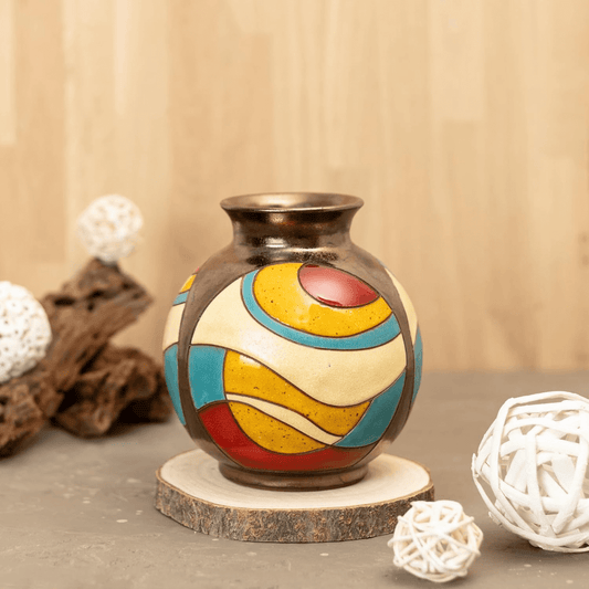 Decorative vase with colorful patterns on a wooden base against a beige background