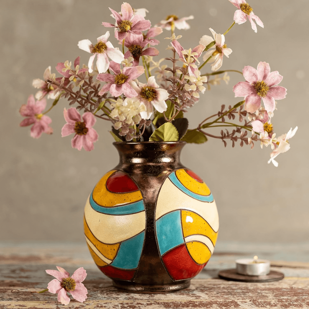 Colorful vase with flowers on a wooden surface