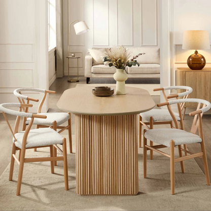 Japandi Wooden Oval Dining Table, set in a modern home with wishbone dining chairs, face view.