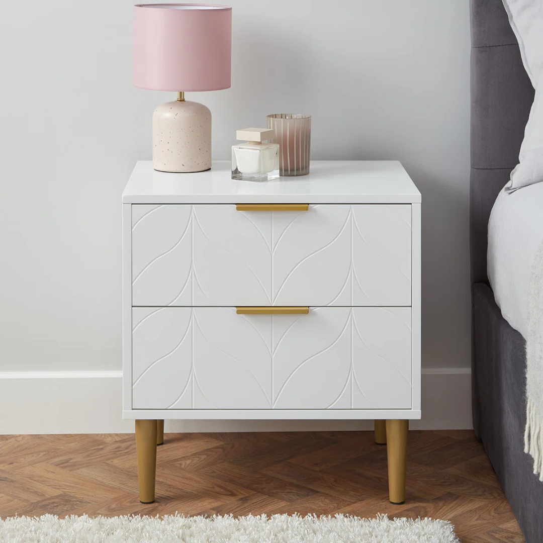 Leaf Design Bedside Table Drawers White, front view, in a bedroom.