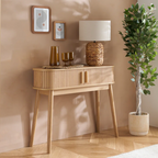 Wooden console table with decorative items against a beige wall.