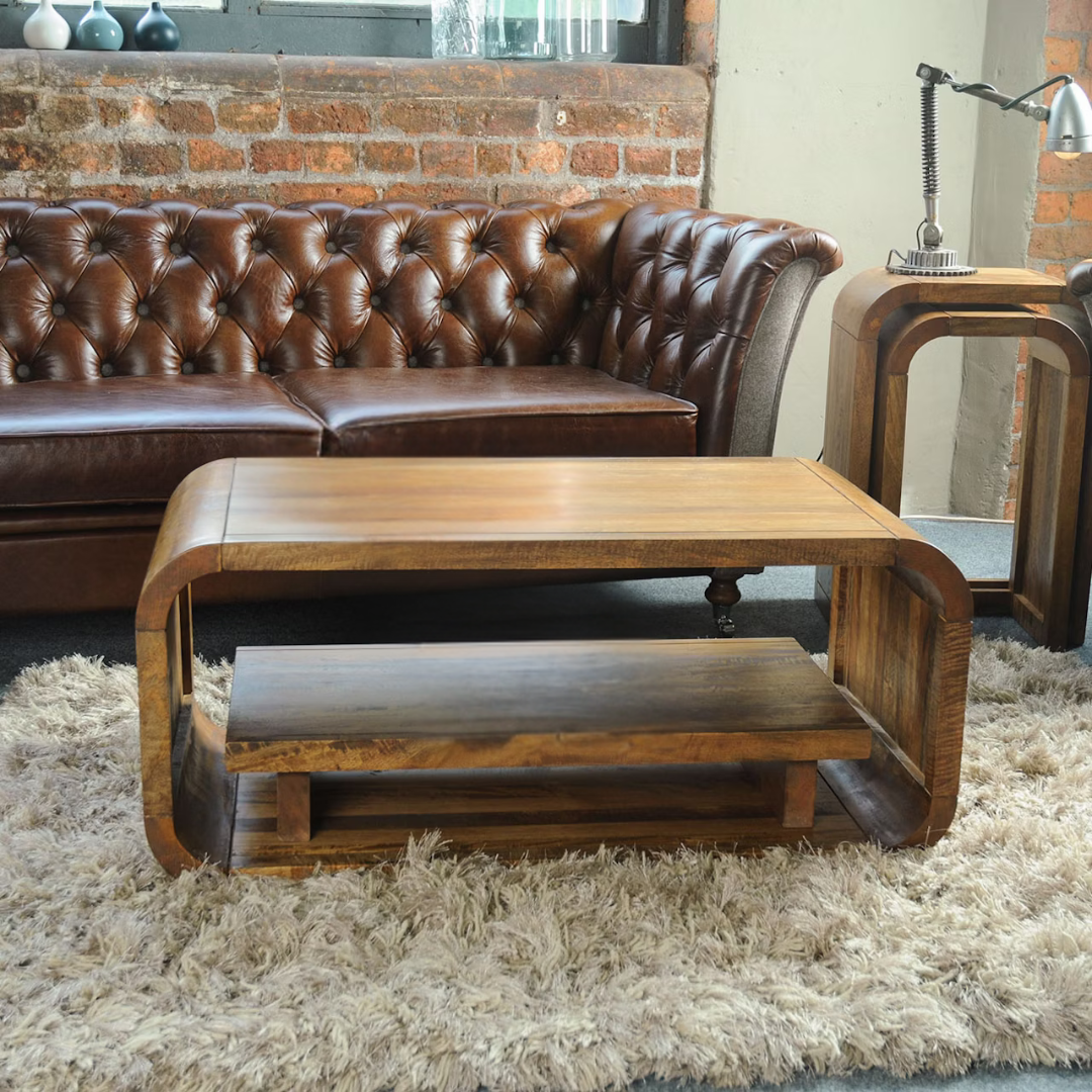 Mango wood curve coffee table with rounded edges, set in a rustic home.