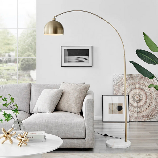 Modern living room with a gray sofa, gold floor lamp, and decorative items.