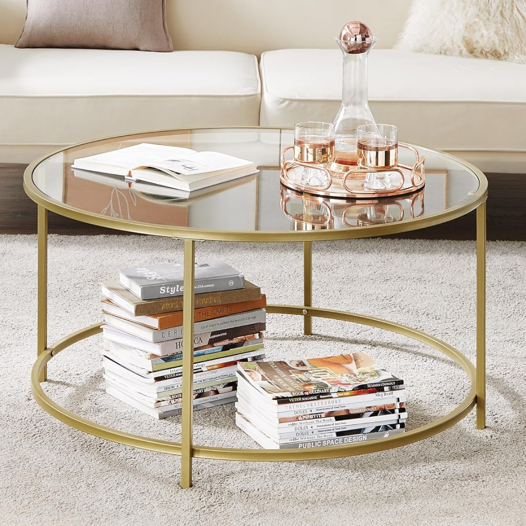 Round gold coffee table with books and a glass on a carpeted floor.