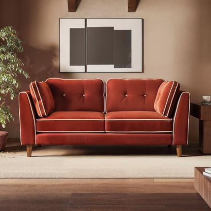 Red velvet sofa in a living room setting with a painting on the wall.