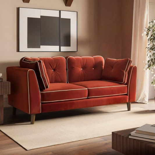 Red velvet sofa in a living room setting with a neutral color palette.