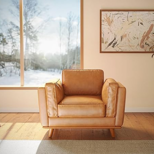Brown leather armchair in a room with a large window and abstract painting on the wall.