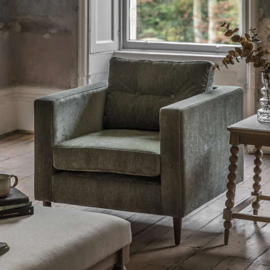 Green armchair in a room with wooden legs 