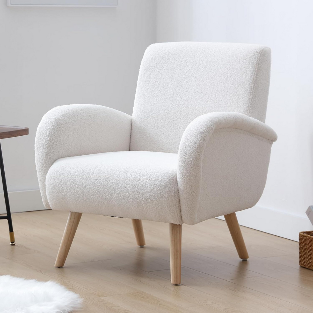 modern faux fur armchair with high back and rounded arms, set up against a white wall.