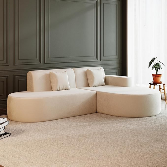 Beige sectional sofa in a room with dark paneled walls and a plant on a small table.