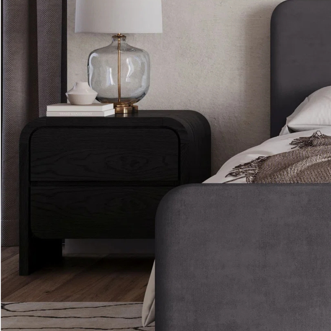 Modern Solid Wood Bedside Cabinet Black, set up next to a bed.