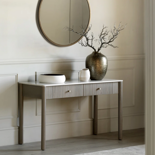 Console table with marble top and decorative items against a neutral wall
