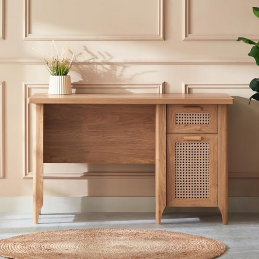 Wooden desk with a woven drawer front against a beige wall.