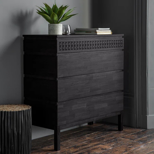Modern Solid Black Wooden Chest Of Drawers, set in a modern home, angled view.