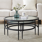 Round glass coffee table with black metal frame in a living room setting.