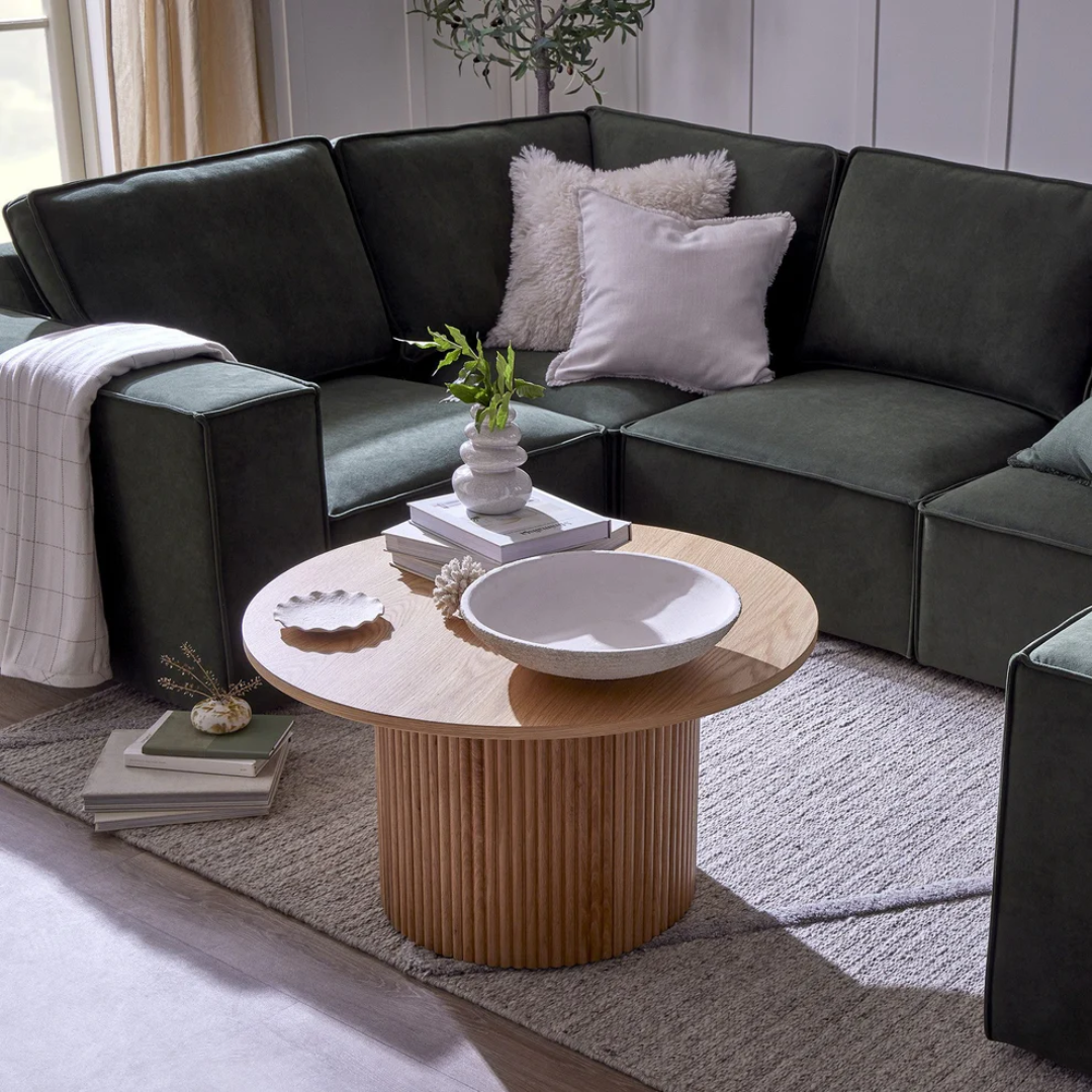 Modern living room with a dark gray sectional sofa and wooden coffee table.