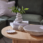Decorative items on a wooden coffee table with a green sofa in the background