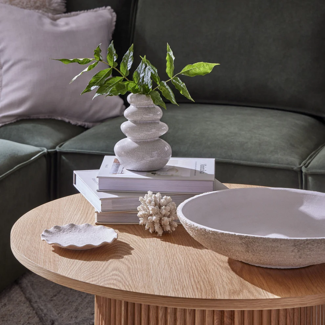 Decorative items on a wooden coffee table with a green sofa in the background