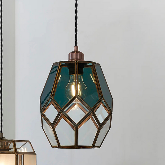 Geometric glass pendant light with brass accents on a plain background