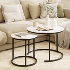 Round marble coffee table with black metal legs in a living room setting.