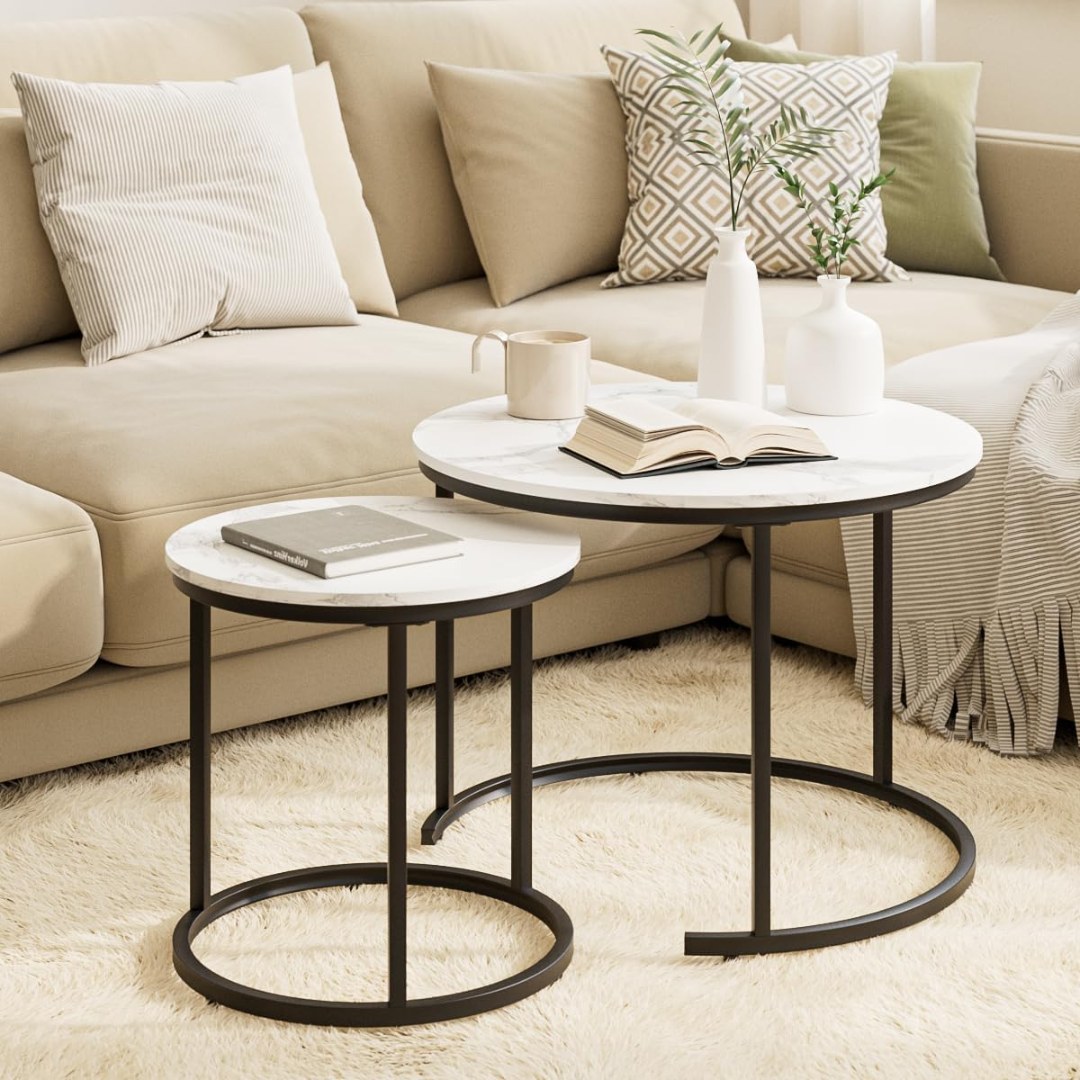 Round marble coffee table with black metal legs in a living room setting.