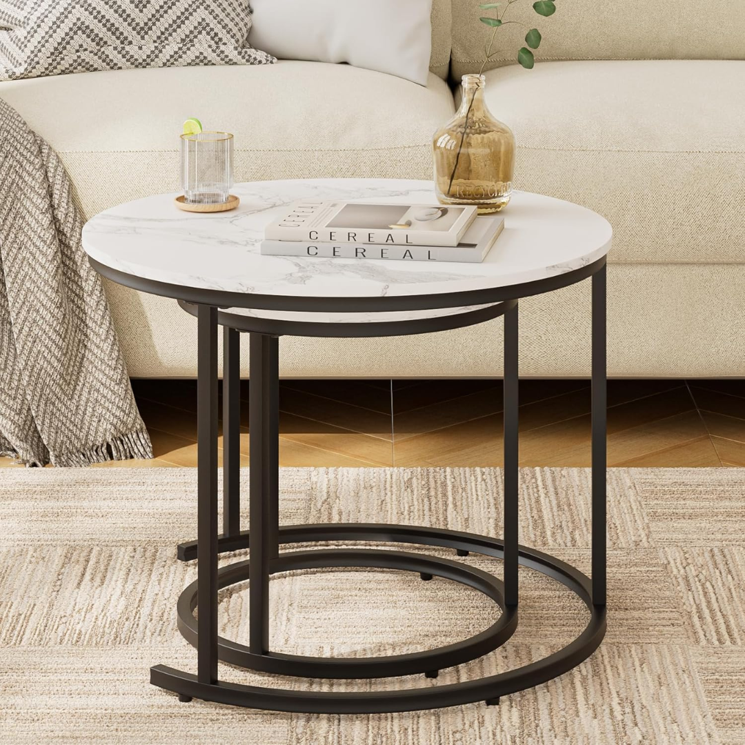 Round marble top side table with black metal base in a living room setting.