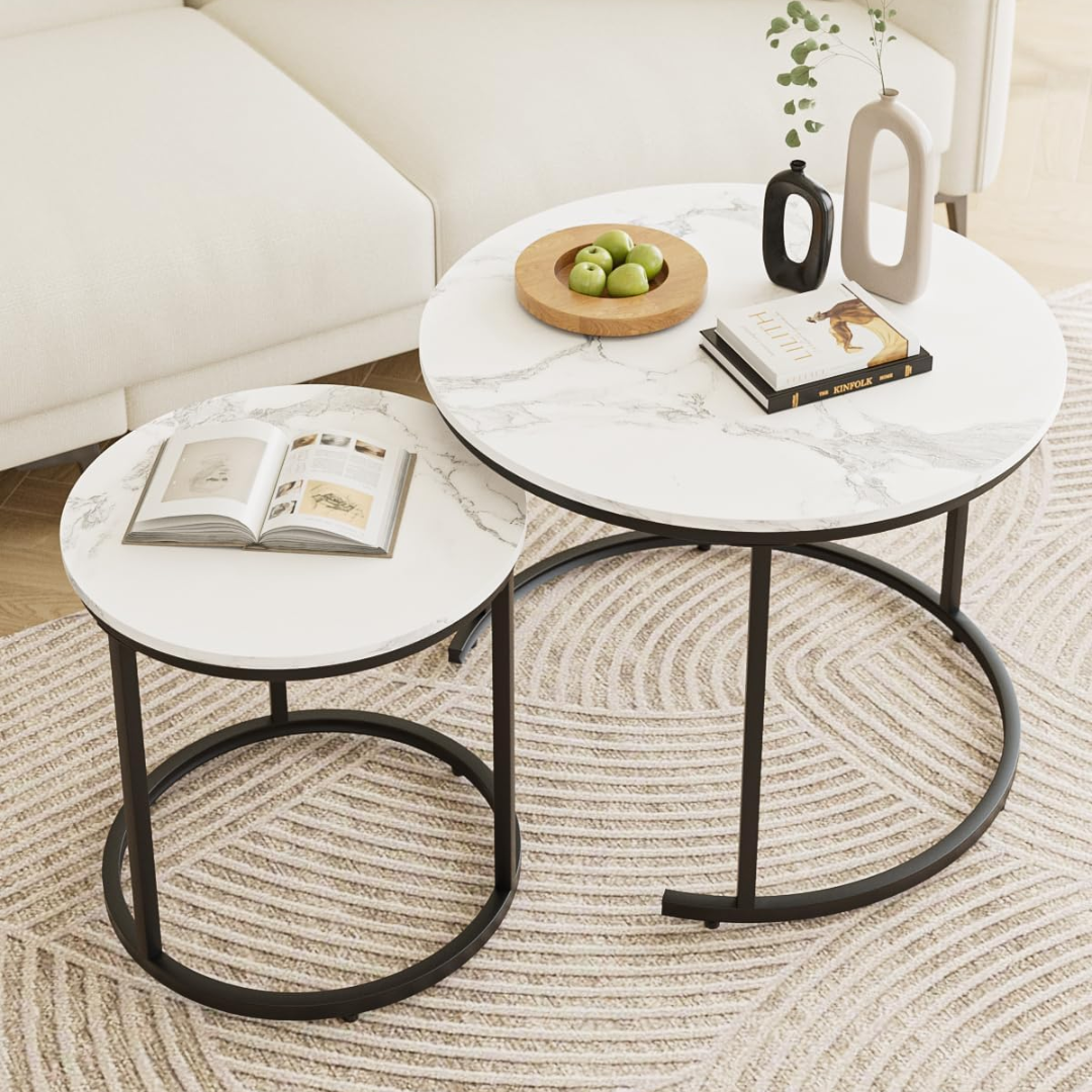 Two marble coffee tables with black metal legs in a living room setting.