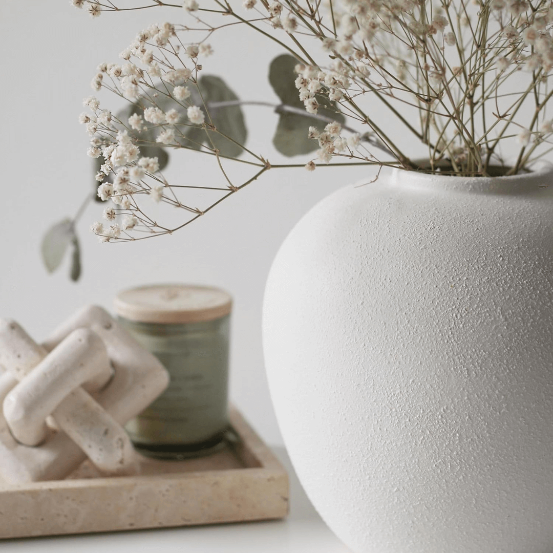 White textured vase with dried flowers on a light background