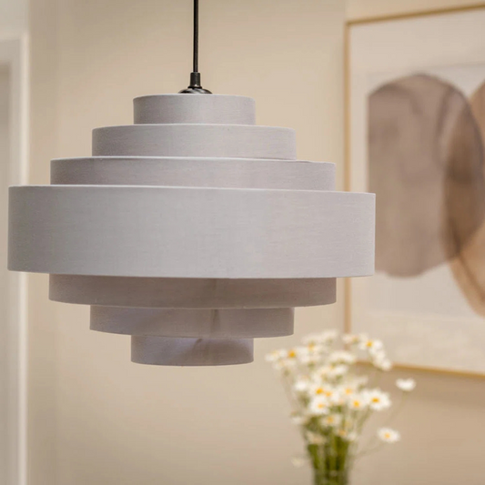 Gray pendant lamp hanging in a room with a blurred background