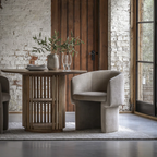 Modern interior with a wooden table and gray chair against a brick wall.