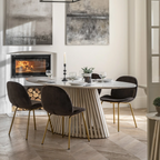 Modern dining room with a marble table and black chairs in front of a fireplace.