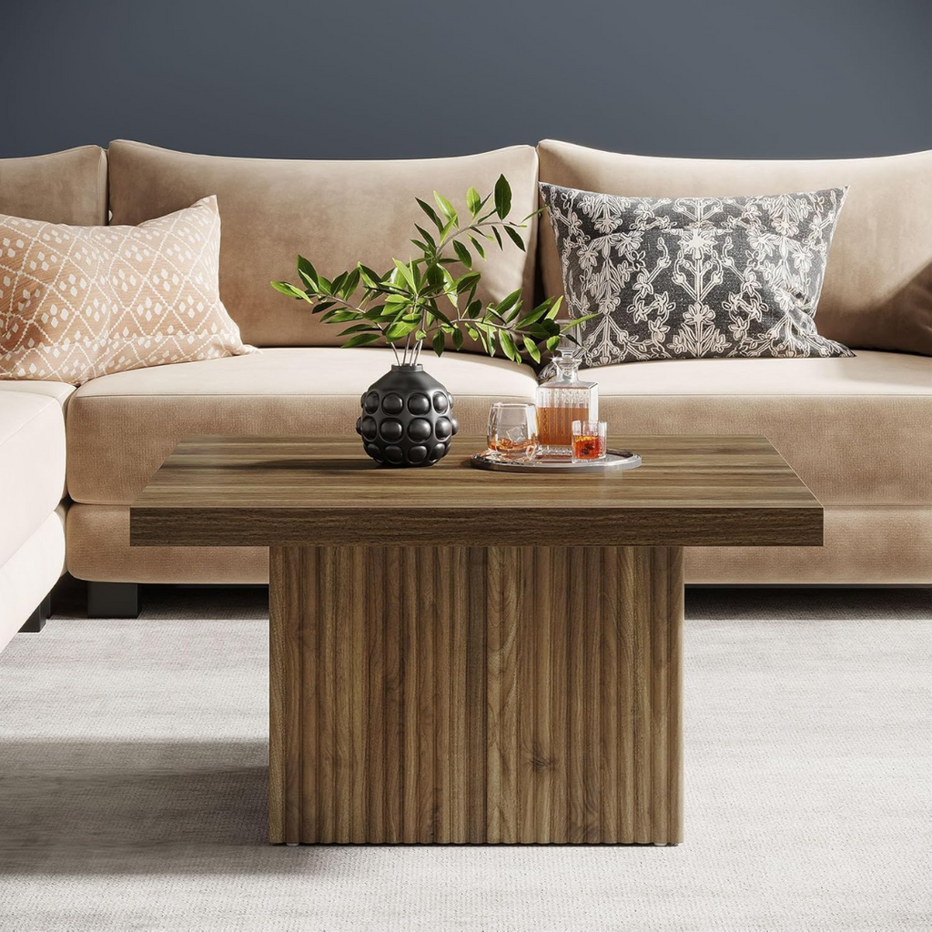Beige sofa with decorative pillows and a wooden coffee table in a living room setting.