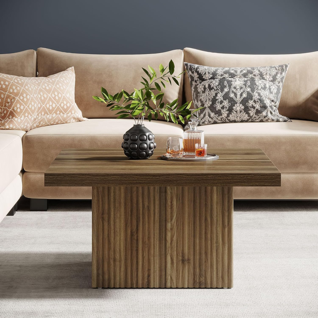 Beige sofa with decorative pillows and a wooden coffee table in a living room setting.