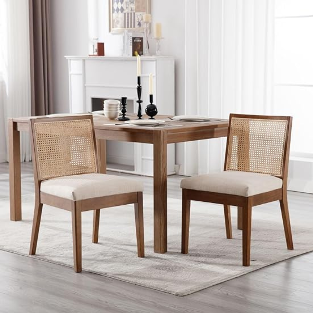 Dining table with two chairs in a room with a fireplace and large windows.