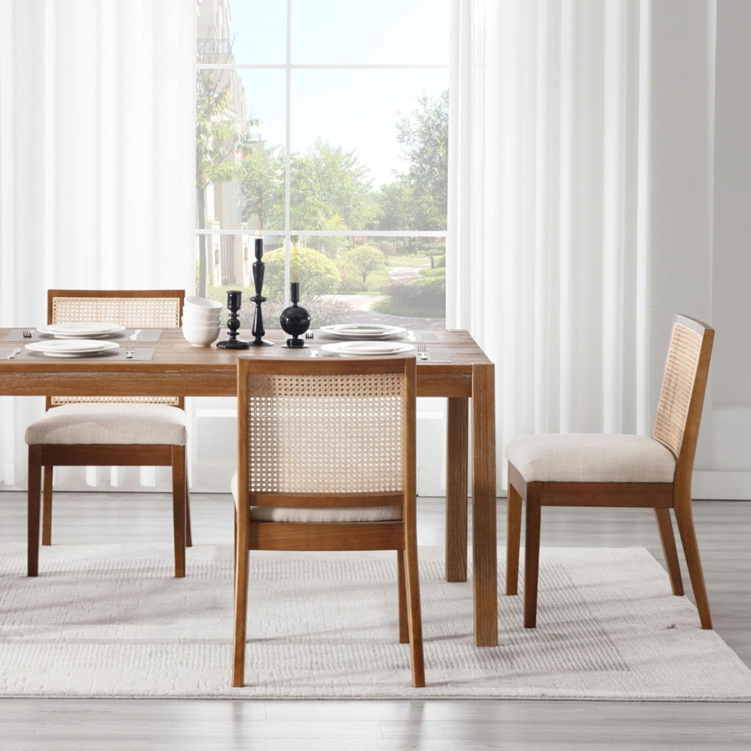 Dining room with wooden table and chairs on a light rug.
