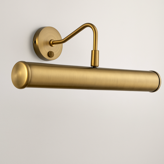 Gold wall-mounted lamp with cylindrical shade on a light gray background