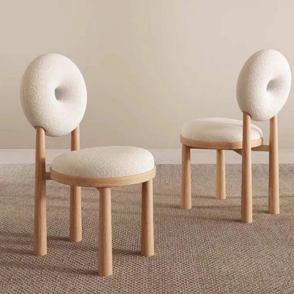 white boucle dining chair with curved back and soft seat, angled view in a home setting.