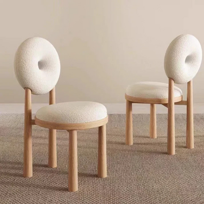 white boucle dining chair with curved back and soft seat, angled view in a home setting.