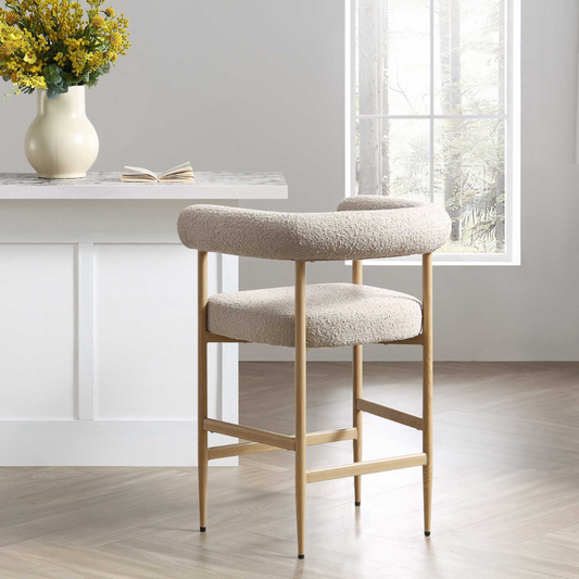 Beige bar stool in a modern kitchen setting with a vase of flowers and a window in the background.