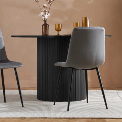 Dining table with gray chairs against a beige wall