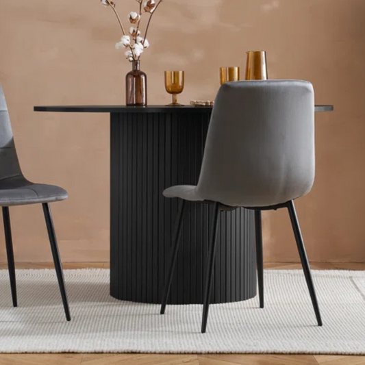 Dining table with gray chairs against a beige wall